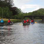 Three canoes paddling in scotland